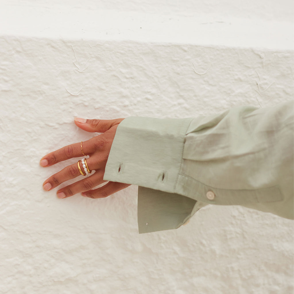 Wanderlust Life Deep Dive Pearl Ring. Freshwater pearls form this beaded style elasticated ring. Styled with our gold band stacking rings. The perfect statement ring for summer for 2023's pearl  jewellery trend. Designed and handcrafted in our Devon studio.