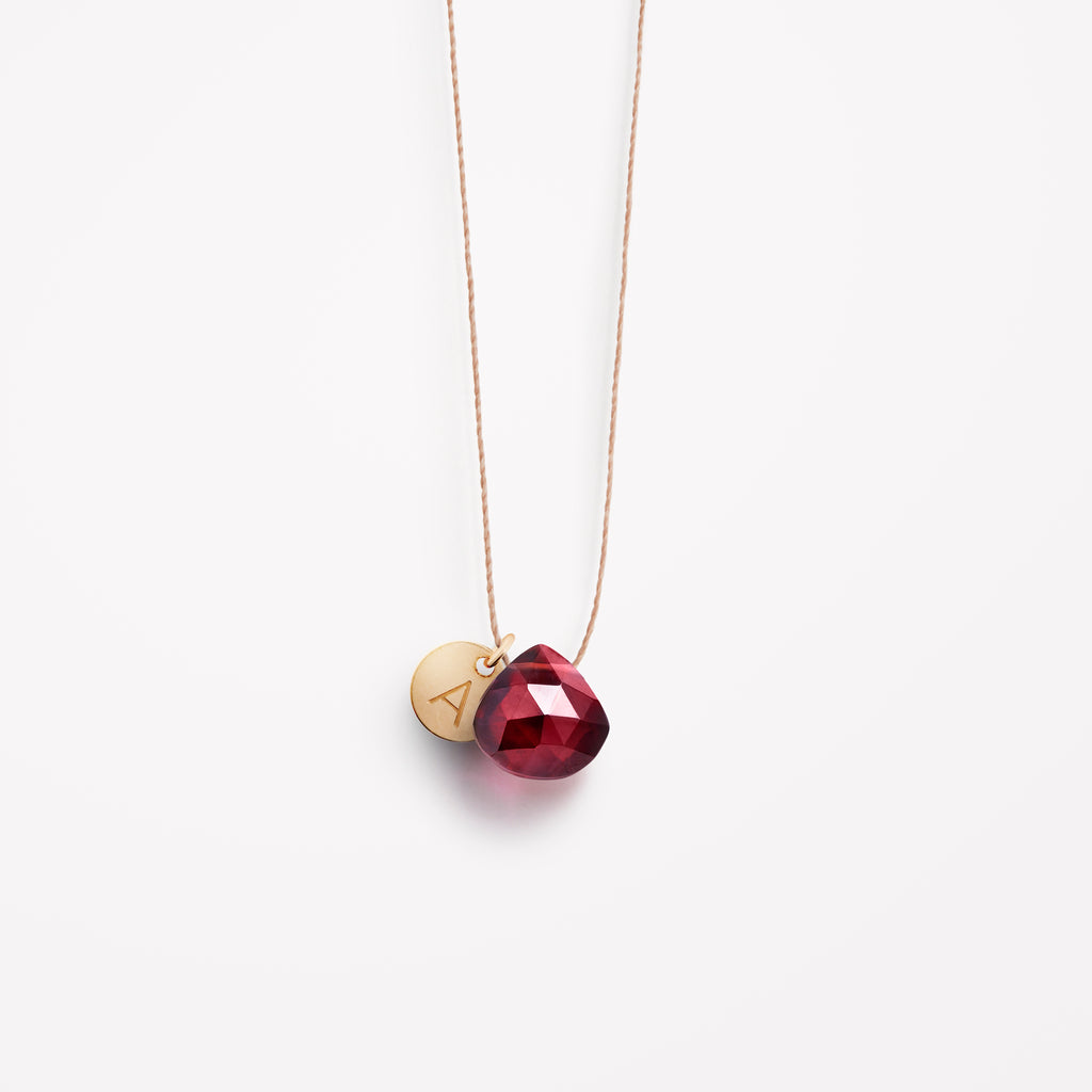 Wanderlust Life Ethically Handmade jewellery made in the UK. Minimalist gold and fine cord jewellery. january birthstone, garnet fine cord necklace. Personalised garnet necklace with gold personalised tag jewellery, handmade in the UK.